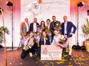 Techathon 2024 Winnaars - Team van 9 mannen en vrouwen poseren met gewonnen geldprijs van 5000 euro